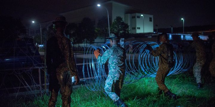 Military personnel install barbed wire around the Top Glove worker's hostel in Klang, Malaysia, on Nov. 17.