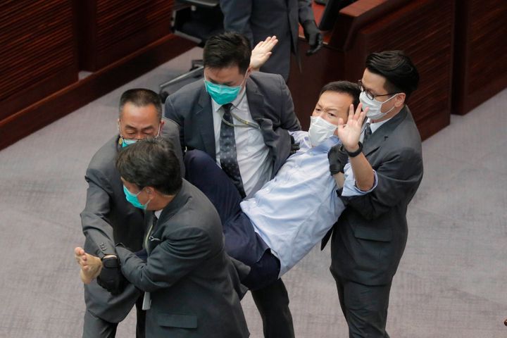 Pan-democratic legislator Raymond Chan Chi-chuen is taken away by security guards during a Legislative Council's House Commit