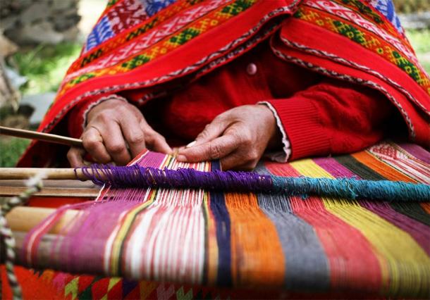 Close up of an indigenous Peruvian woman weaving a traditional textile near Machu Picchu. (Shannon / Adobe Stock)
