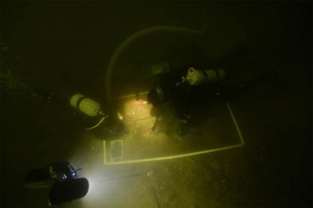 Underwater archaeologists examining the artifacts in Lake Asveja, Lithuania. (G. Krakauskas)