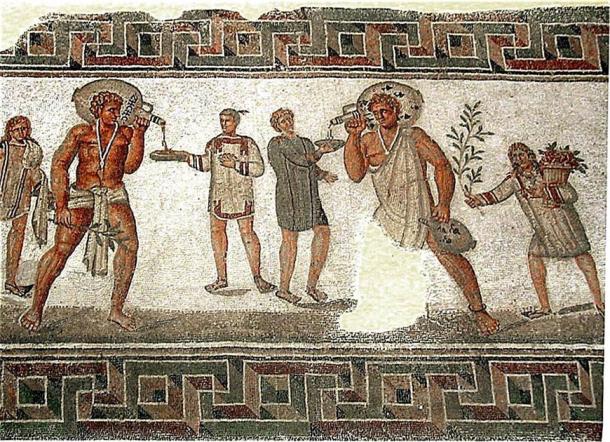 Roman mosaic from Dougga, Tunisia (2nd century AD): the two slaves carrying wine jars wear typical slave clothing and an amulet against the evil eye on a necklace; the slave boy to the left carries water and towels, and the one on the right a bough and a basket of flowers. (Pascal Radigue/CC BY 3.0)