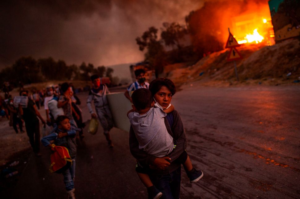 Thousands of asylum-seekers on the Greek island of Lesbos flee for their lives on Sept. 9 as a huge fire rips through the cam