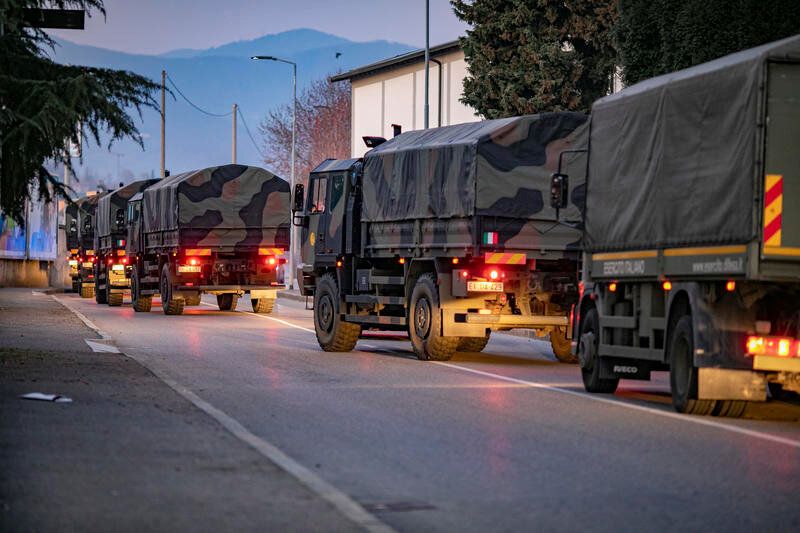 Italian military trucks drive through the streets of Bergamo, Italy, on March 18 after the army was deployed to move coffins 