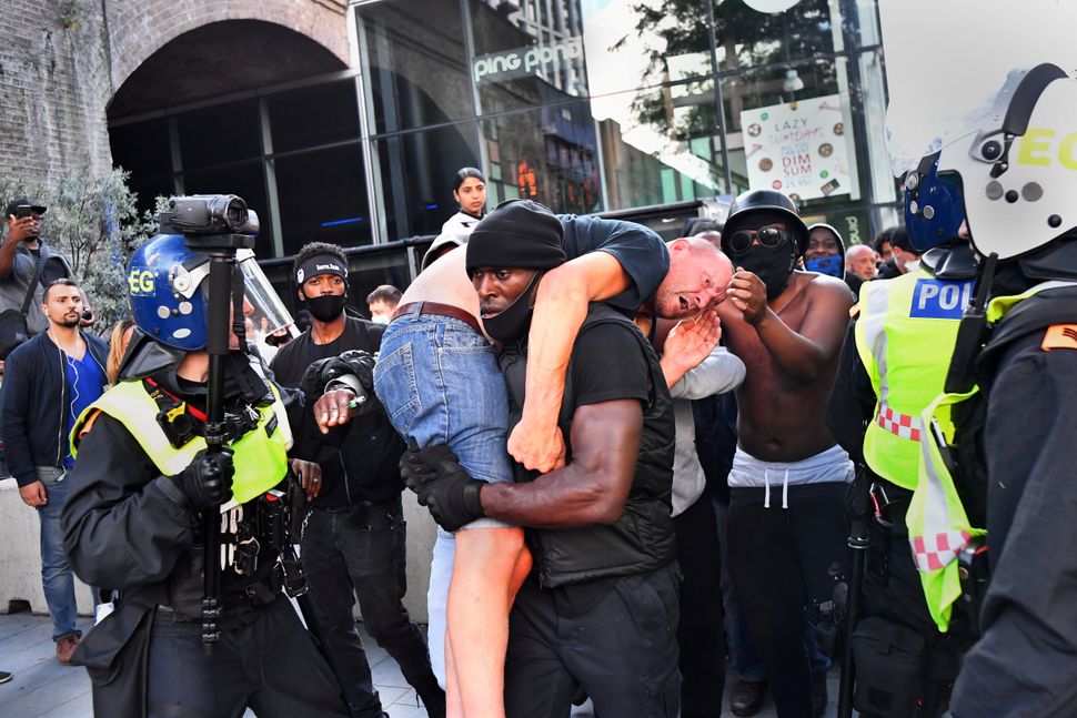Patrick Hutchinson carries an injured far-right counterprotester named Bryn Male to safety near London's Waterloo station dur