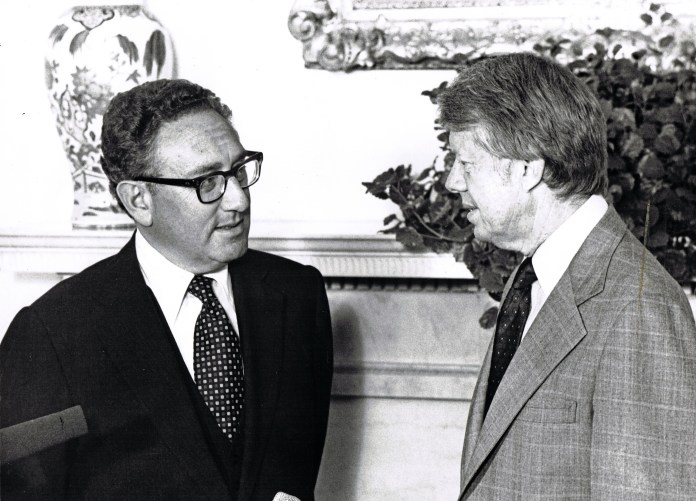 Former US Secretary of State Henry Kissinger (left) and President Jimmy Carter talk in the White House's Oval Office, Washington DC, August 15, 1977
