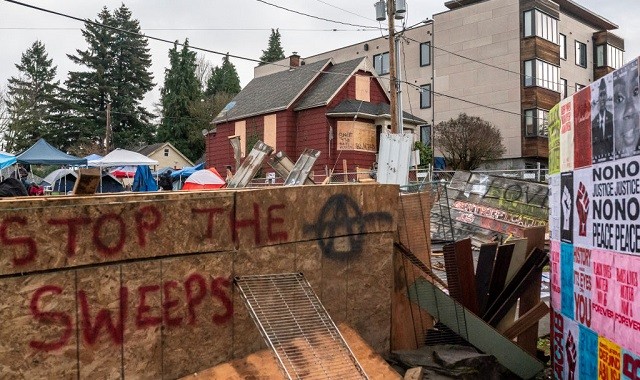 PORTLAND, OR - DECEMBER 09: Layers of chainlink fence and wood block the entry to the Red House on Mississippi Street on December 9, 2020 in Portland, Oregon. Police and protesters clashed during an attempted eviction Tuesday morning, leading protesters to establish a barricade around the Red House. (Photo by Nathan Howard/Getty Images)