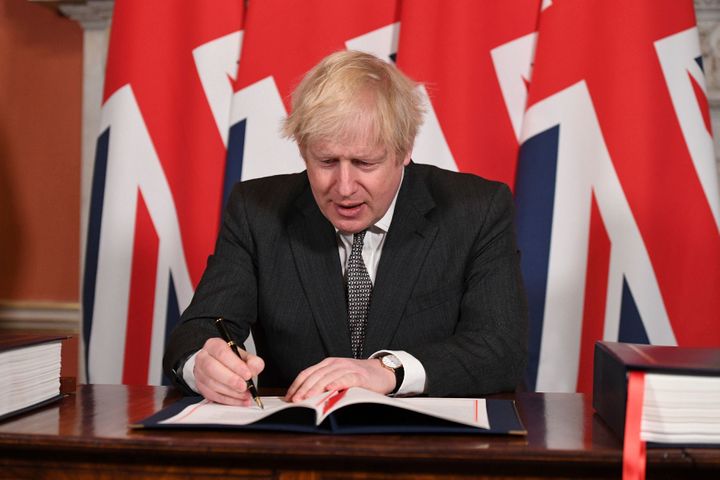 Britain's Prime Minister Boris Johnson signs the EU-UK Trade and Cooperation Agreement at 10 Downing Street, London Wednesday
