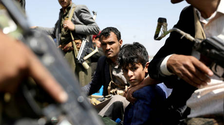 FILE PHOTO: A boy rides with Houthi followers on the back of a patrol truck during the funeral of Houthi fighters killed during recent battles against government forces, in Sanaa, Yemen September 22, 2020.
