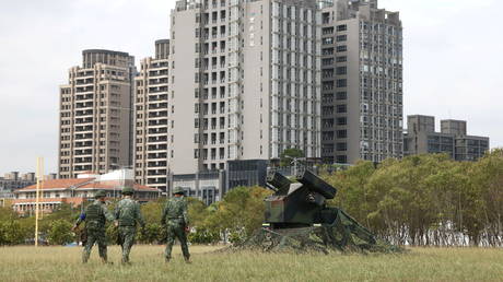 FILE PHOTO: Soldiers walk past a AN/TWQ-1 Avenger mobile air defense missile system during 'Combat Readiness Week' drills in Hsinchu, Taiwan, October 29, 2020