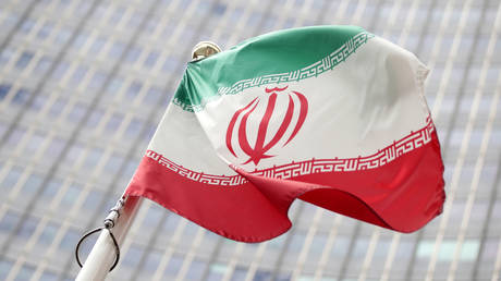 FILE PHOTO: The Iranian flag flutters in front the International Atomic Energy Agency (IAEA) headquarters in Vienna, Austria. © REUTERS / Lisi Niesner