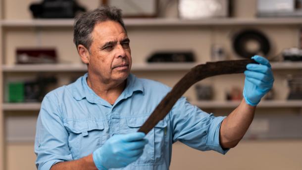 Dave Johnston, Professor of Archaeology from the Australian National University analyzing one of sixe boomerangs discovered recently in Australia. (Jamie Kidston /Australian National University)
