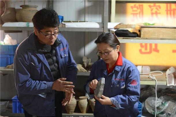 Zhang Yanglizheng and Xu Weihong, a researcher from the academy and leader of the team, study relics found at the ancient Xianyang site. (Zhang Xiping / China Daily)
