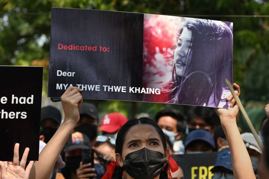 A protester holds up a poster with a portrait of Mya Thwate Thwate Khaing who died from a gunshot wound after being shot in t