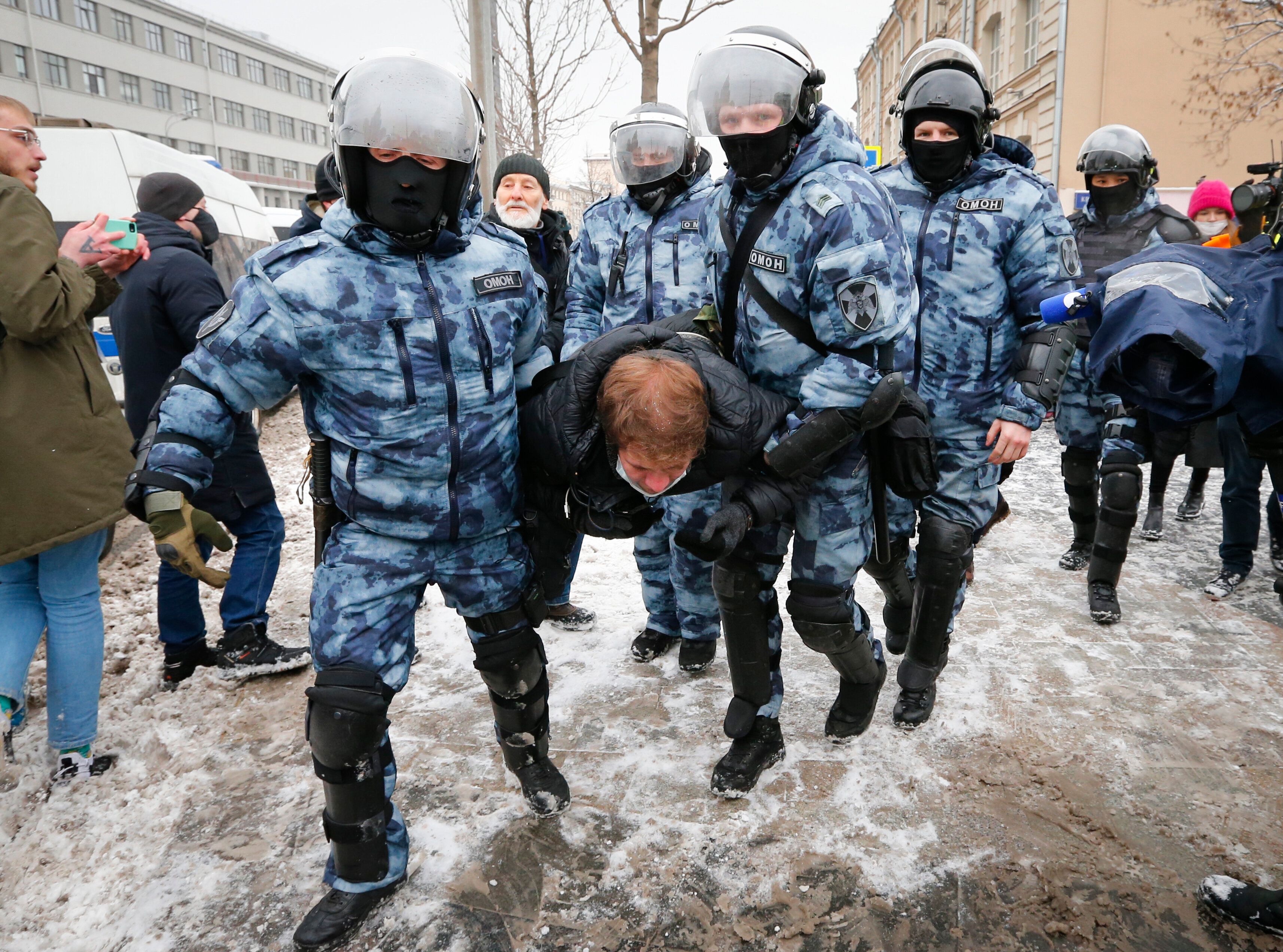 Police officers detain a man during a protest against the jailing of opposition leader Alexei Navalny in Moscow, Russia, on S