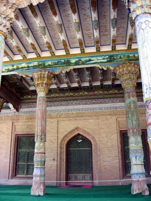 An interior photo of the Afaq Khoja Mausoleum showing both wooden pillars and beams colorfully decorated. (Colegota / CC BY-SA 2.5 ES)