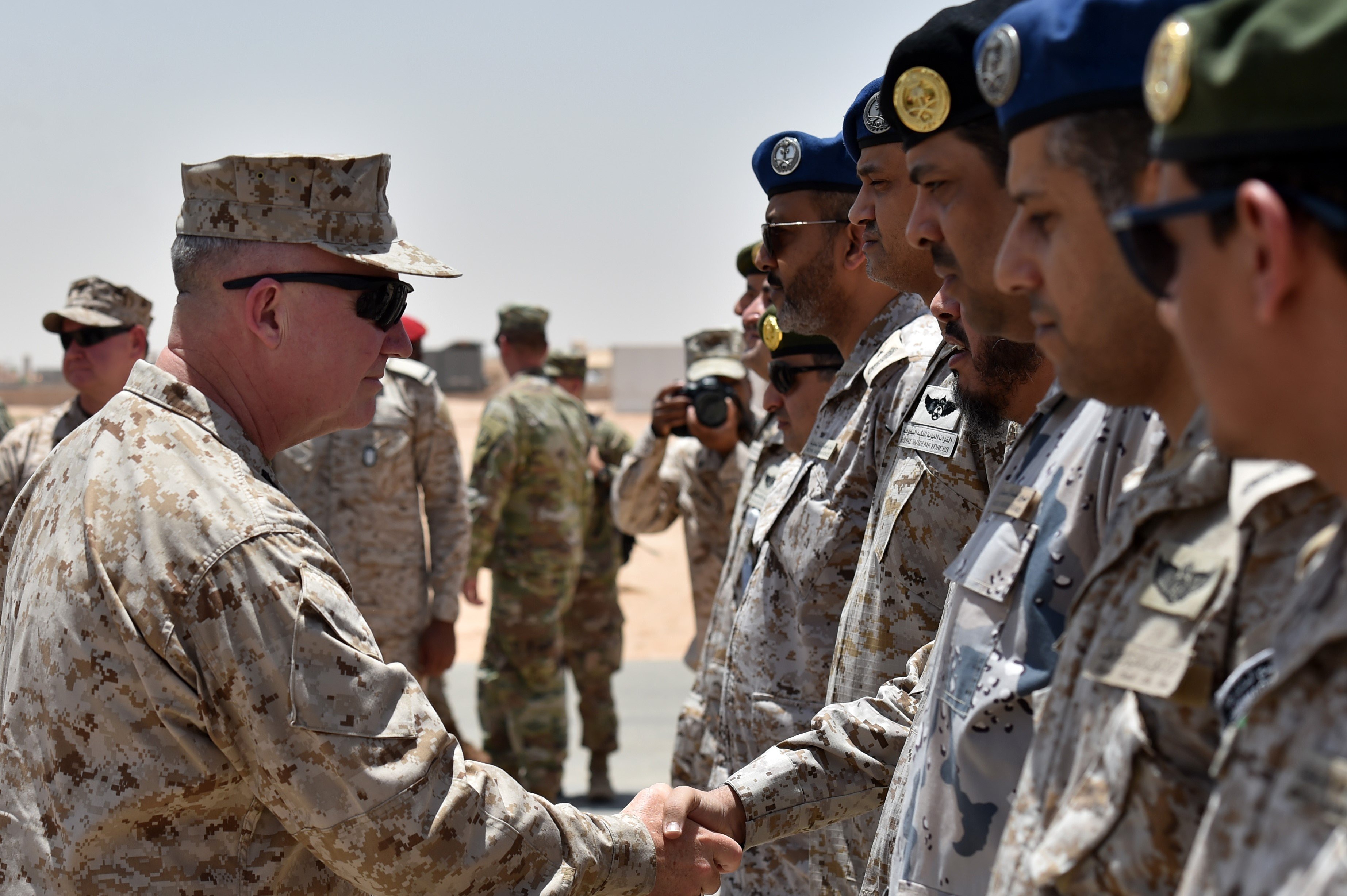 US Marine Corps General Kenneth F. McKenzie Jr. (L), Commander of the US Central Command (CENTCOM), shakes hands with Saudi military officers during his visit to a military base in al-Kharj in central Saudi Arabia on July 18, 2019.