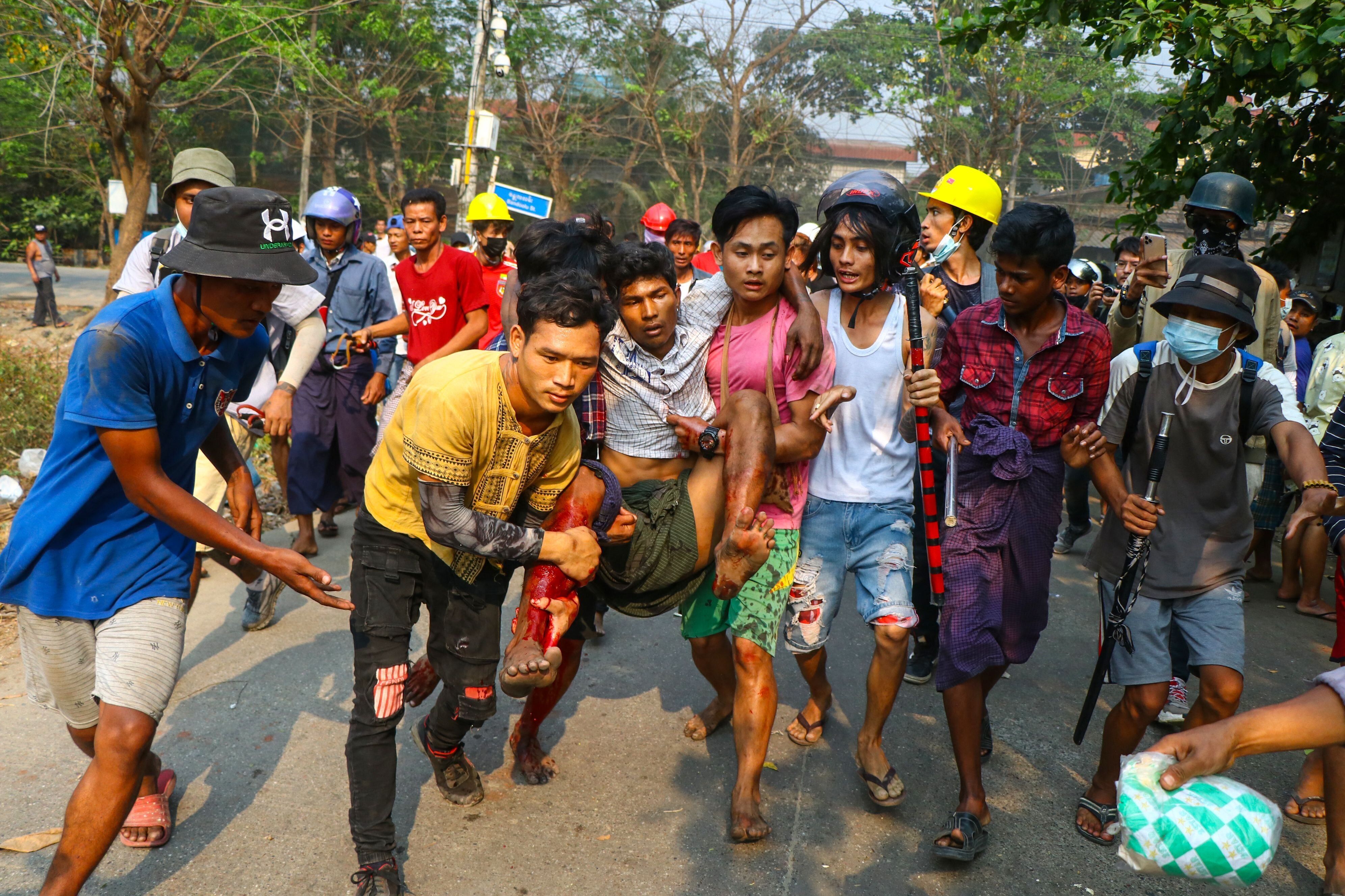 A resident, who was injured during a demonstration by protesters against the military coup, is carried to safety in Yangon on