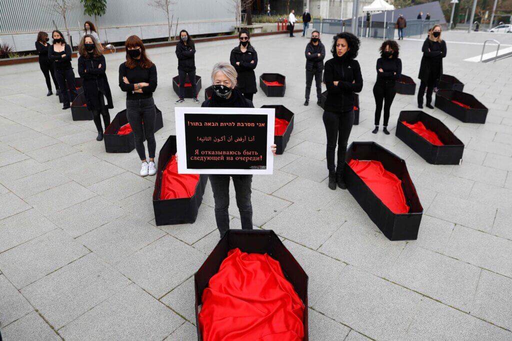 An Israeli woman holds a placard that reads "I refuse to be next" as others stand next to mock coffins to represent those killed as a result of domestic violence, outside the District Court in the Israeli coastal city of Tel Aviv, on March 7, 2021 ahead of the International Women's day. (Photo: Jack Guez/AFP/Getty Images)