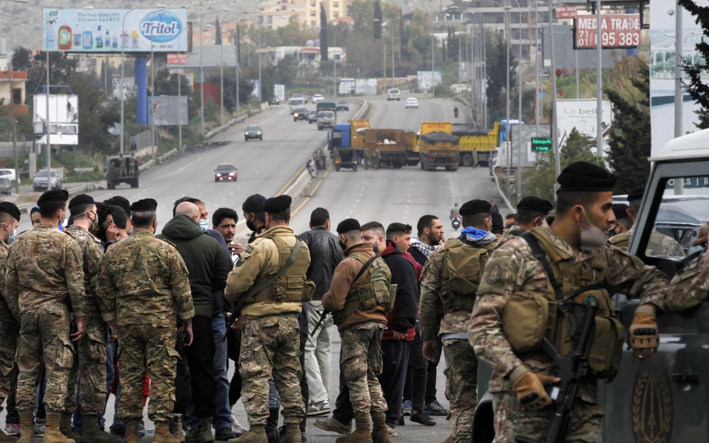 Lebanese security forces try to open a road blocked protesters south of Beirut on 10 March 2021 (Mahmoud Zayyat/AFP)