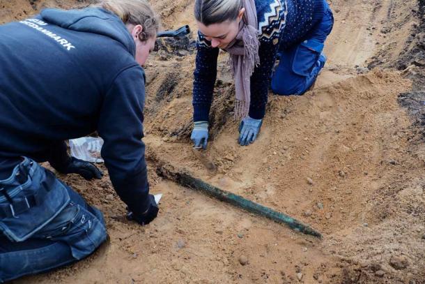 Archaeologists carefully extracting the sword from the excavation site in Håre, Denmark (Odense City Museums)