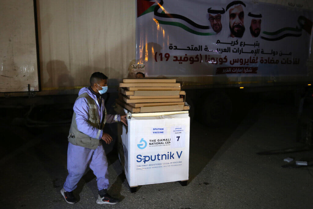 Workers unload from a truck boxes of Russia's Sputnik V vaccine sent by United Arab Emirates at the Rafah crossing in southern Gaza on March 11, 2021. (Photo: Ashraf Amra/APA Images)