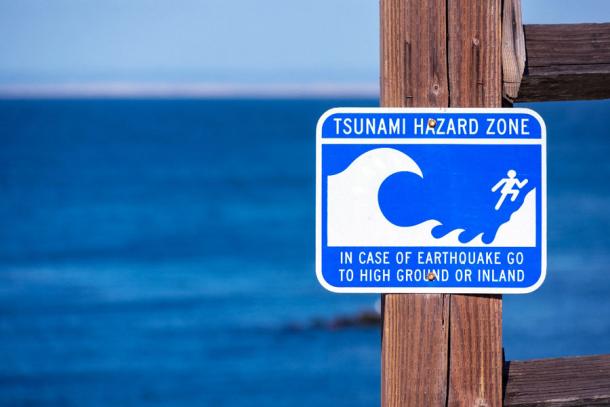 Tsunami ≈ zone warning sign on the Pacific Ocean coast warns the public about possible danger after an earthquake, and many Native American tribes are preparing for the “next” Cascadia earthquake. (MichaelVi / Adobe Stock)