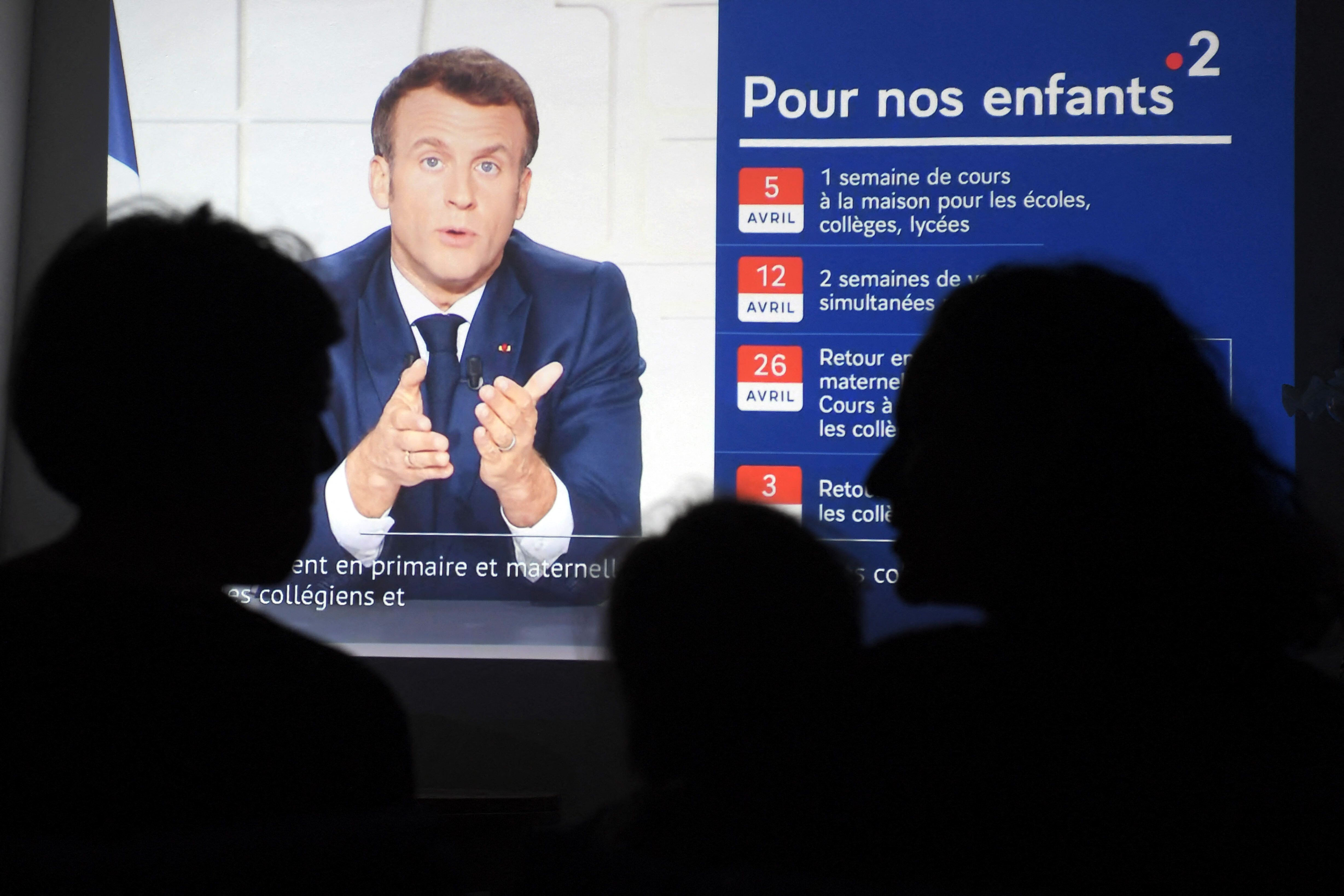 People listen to French president Emmanuel Macron delivering a broadcast speech from the Elysee palace in Paris, in Marseille