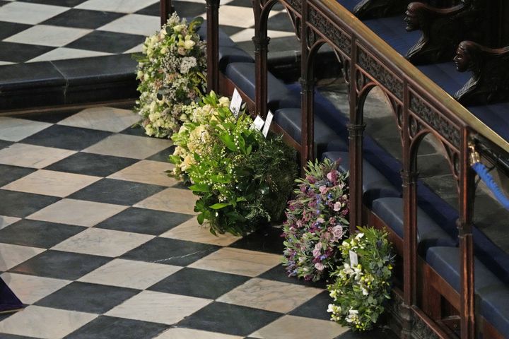Wreaths from members of the royal family lie against the pews during the funeral.