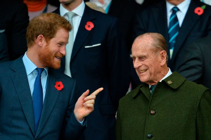 Prince Harry speaks with his grandfather Prince Philip as they watch the final match of the Rugby World Cup on Oct. 31, 2015.