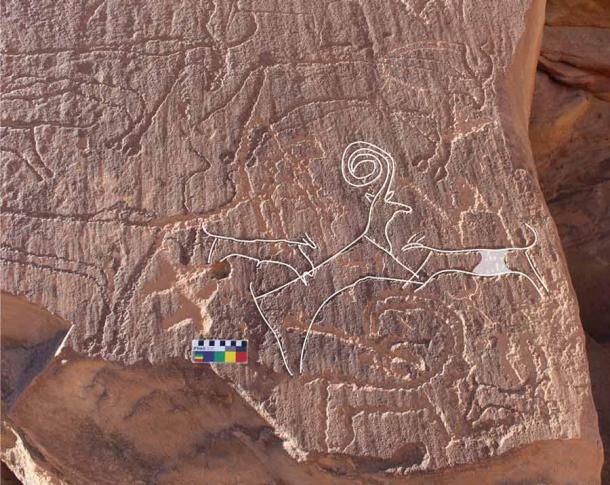 The rock panel found at Al’Ula depicts two dogs hunting an ibex, surrounded by cattle. Experts have dated the engravings to the late Neolithic, which would place it around the time of the recently excavated Saudi Arabian dog burial sites. (Royal Commission of Al-Ula)
