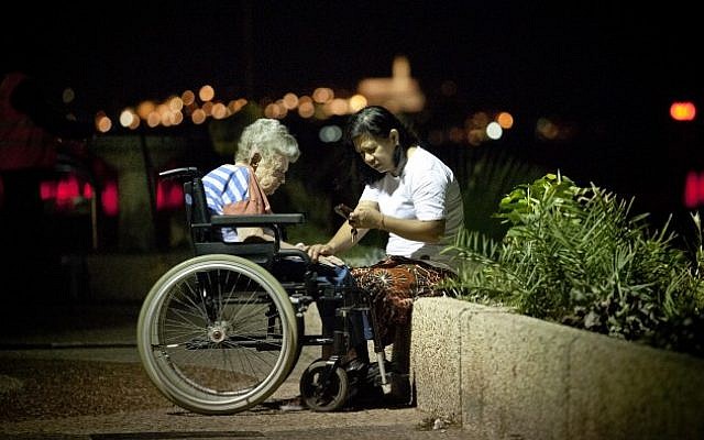 A Filipino caretaker at a promenade in Tel Aviv. (photo credit: Moshe Shai/Flash90)