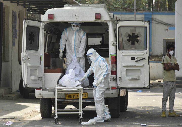 NEW DELHI, INDIA - APRIL 29: Hospital staff members shift dead body of a COVID-19 patient into an ambulance at Maulana Azad M