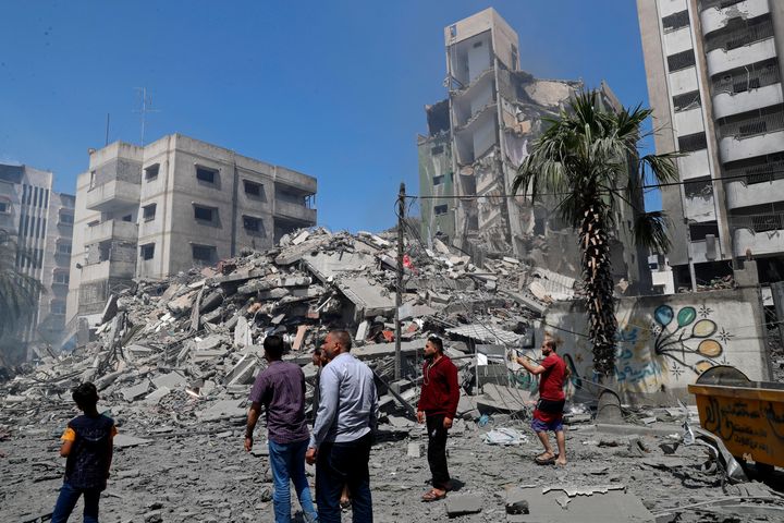 People insect the the rubble of the Yazegi residential building that was destroyed by an Israeli airstrike, in Gaza City, Sun