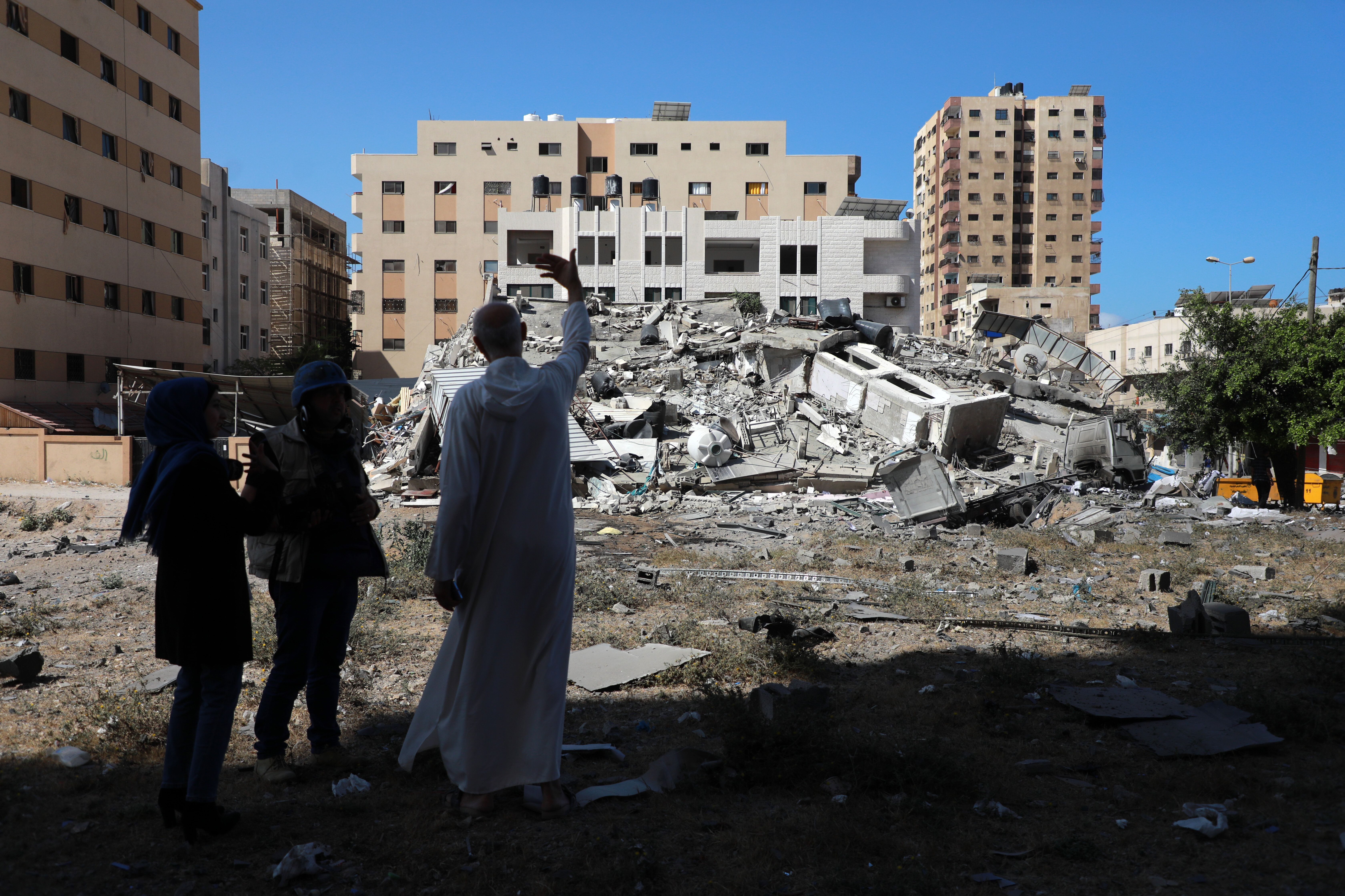 A Palestinian man stands near the remains of a building after it was destroyed in Israeli air strikes in Gaza City on May 18,