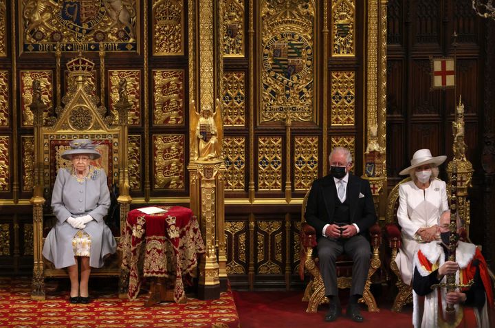 Queen Elizabeth sits on the The Sovereign's Throne in the House of Lords chamber with Prince Charles and Camilla, Duchess of 