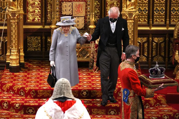 An image showing the queen's crown being carried into the chamber ahead of her on a cushion.