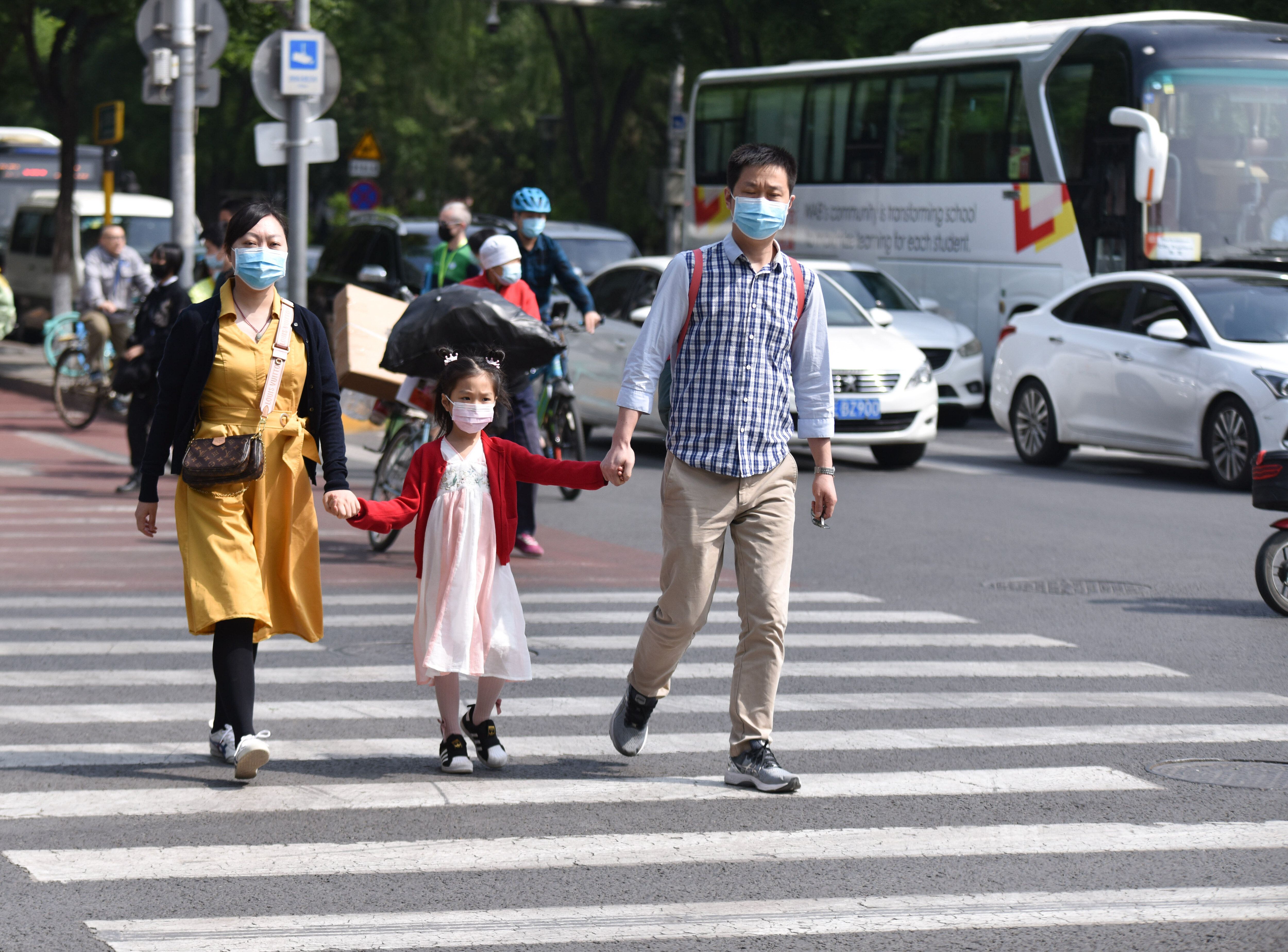 Parents with their kid walk along the Streets of Beijing. China's population has continued to grow since 2020, the National B
