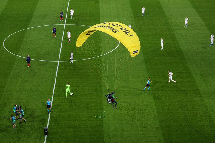 Greenpeace has apologized and Munich police are investigating after a protester parachuted into the stadium and injured two p