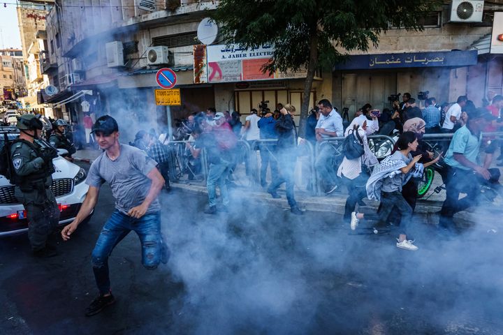 Israeli security forces throw stun grenades Sunday to disperse a crowd gathered for a news conference calling for the release