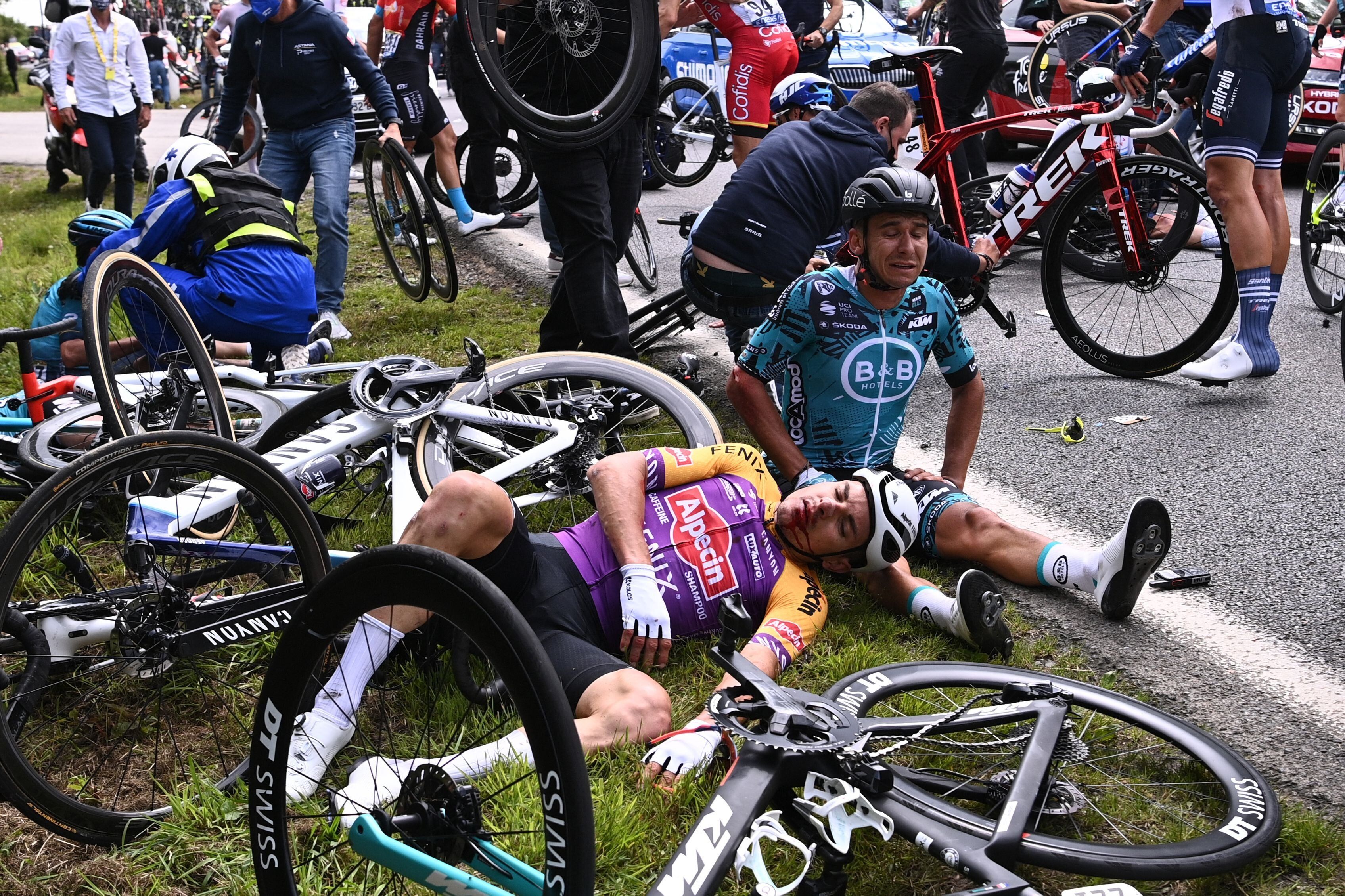 Two cyclists lie on the ground after crashing during the 1st stage of the 108th edition of the Tour de France cycling race on