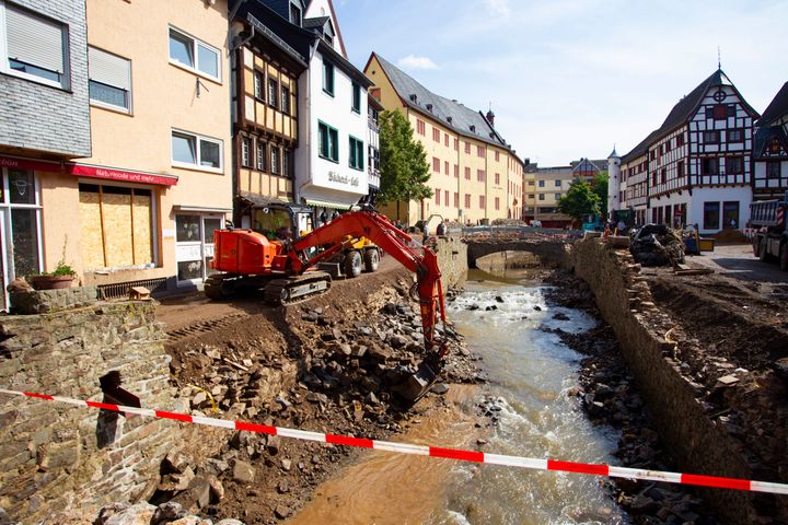 An excavator at work on the banks of the Erft River during clearing operations after flooding in North Rhine-Westphalia.