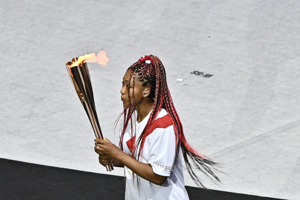 Team Japan's Naomi Osaka carries the Olympic torch.&nbsp;