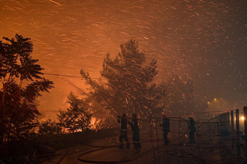 An Athens suburb is engulfed in flames during a wildfire.