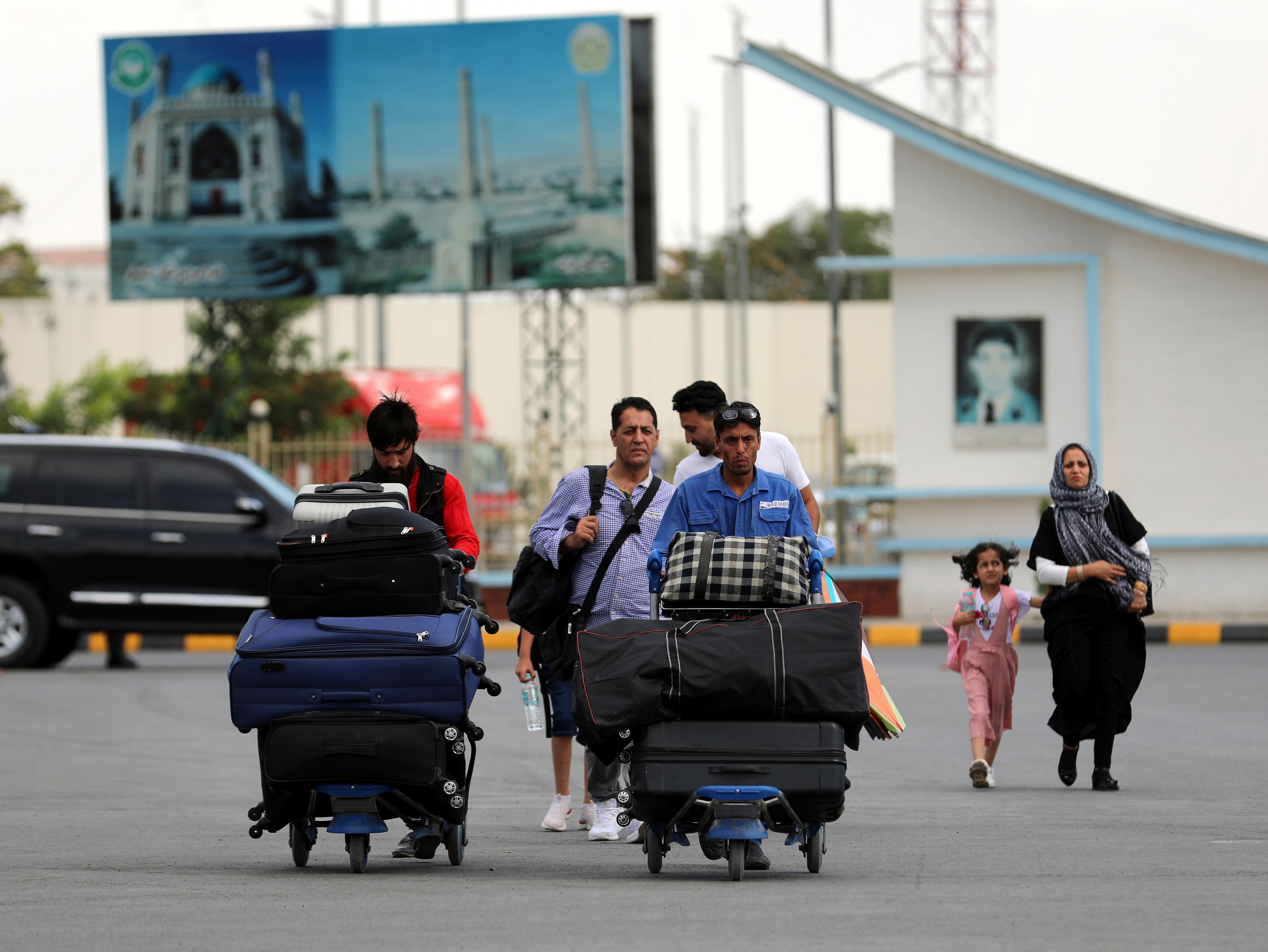 Passengers walk to the departures terminal of Hamid Karzai International Airport in Kabul, Afghanistan, Saturday, Aug. 14, 20