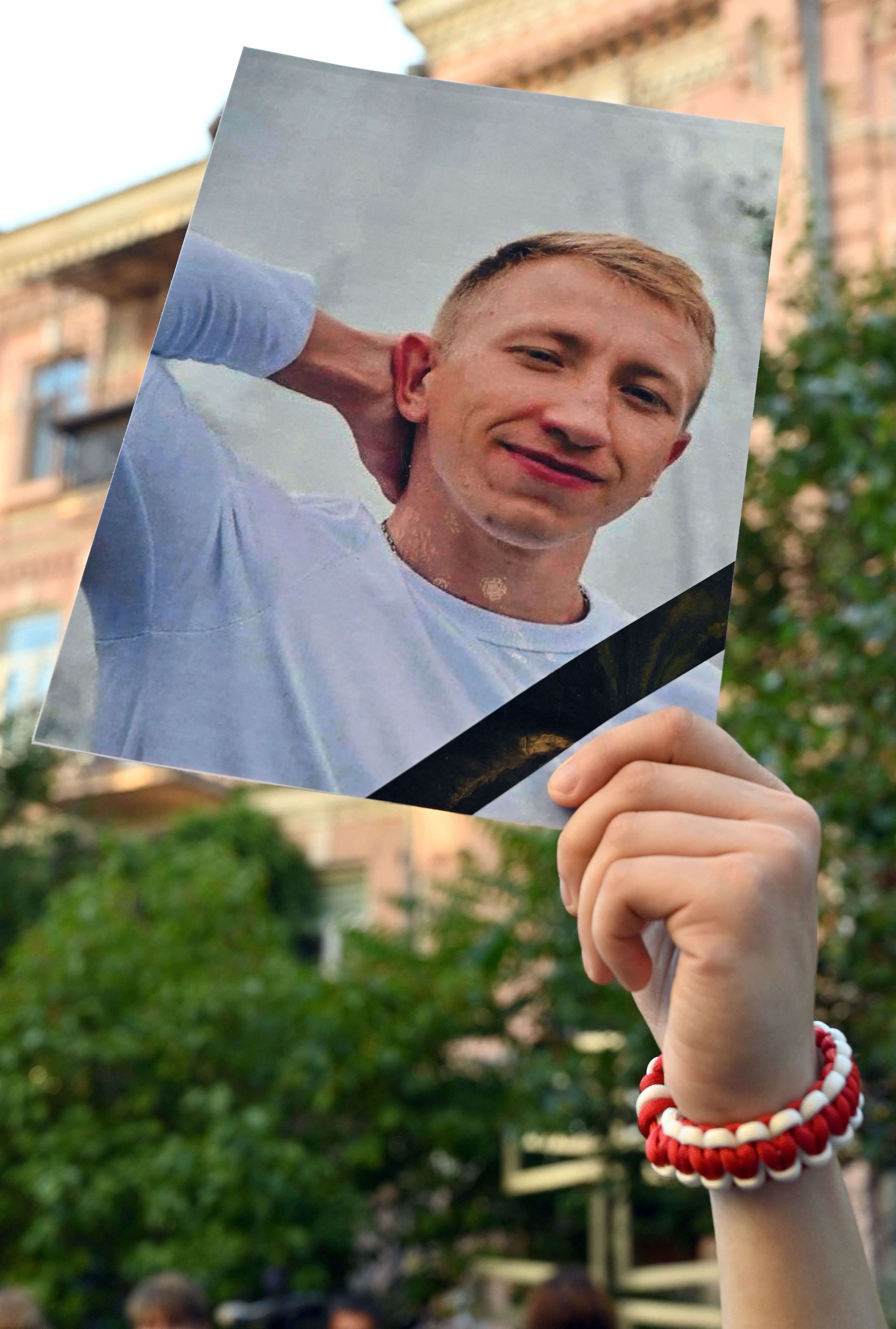 A picture of Vitaly Shishov is held by an activist as he takes part in a rally outside the Belarus embassy in Kiev on August 