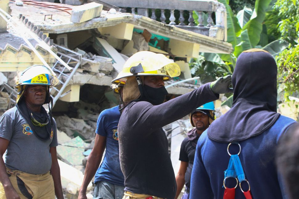 Rescue workers search through destroyed buildings in Les Cayes.