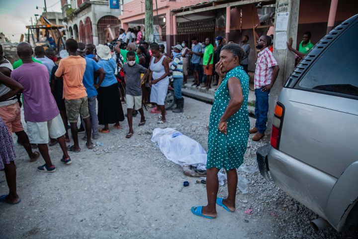 LES CAYES, HAITI - AUGUST 15: Haitians look over a casualty in the 7.2-magnitude earthquake on August 15, 2021 in Les Cayes,