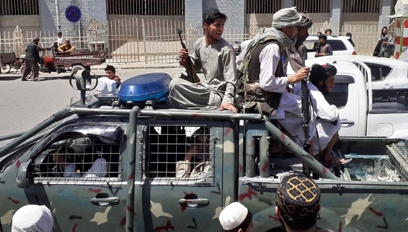 Taliban fighters ride in an Afghan National Directorate of Security car in Kandahar.