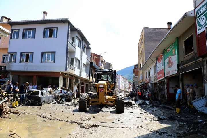 Workers clear the mud from a street in Bozkurt town of Kastamonu province, Turkey, Saturday, Aug. 14, 2021.