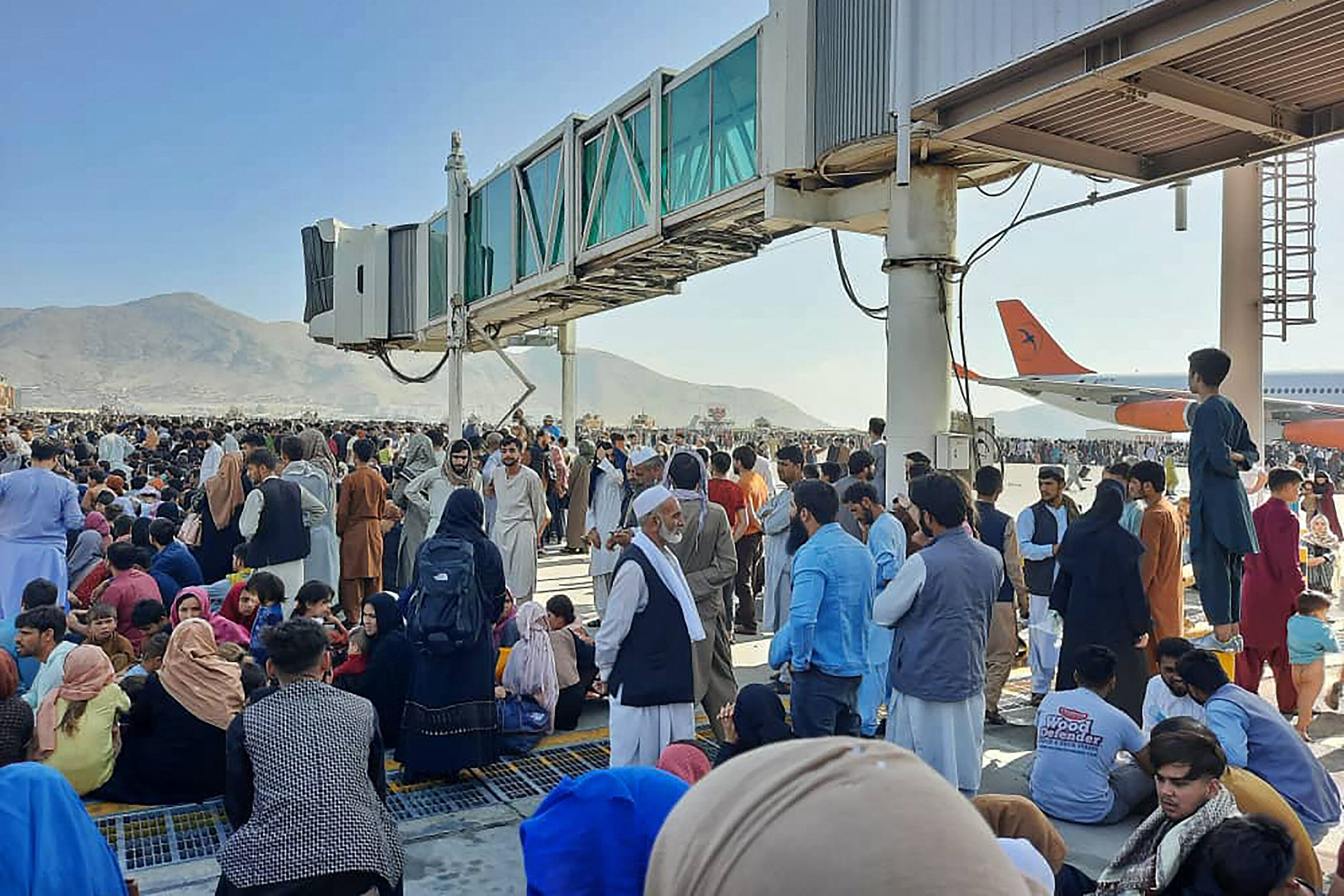 Afghans crowd at the tarmac of the Kabul airport to flee the country.&nbsp;
